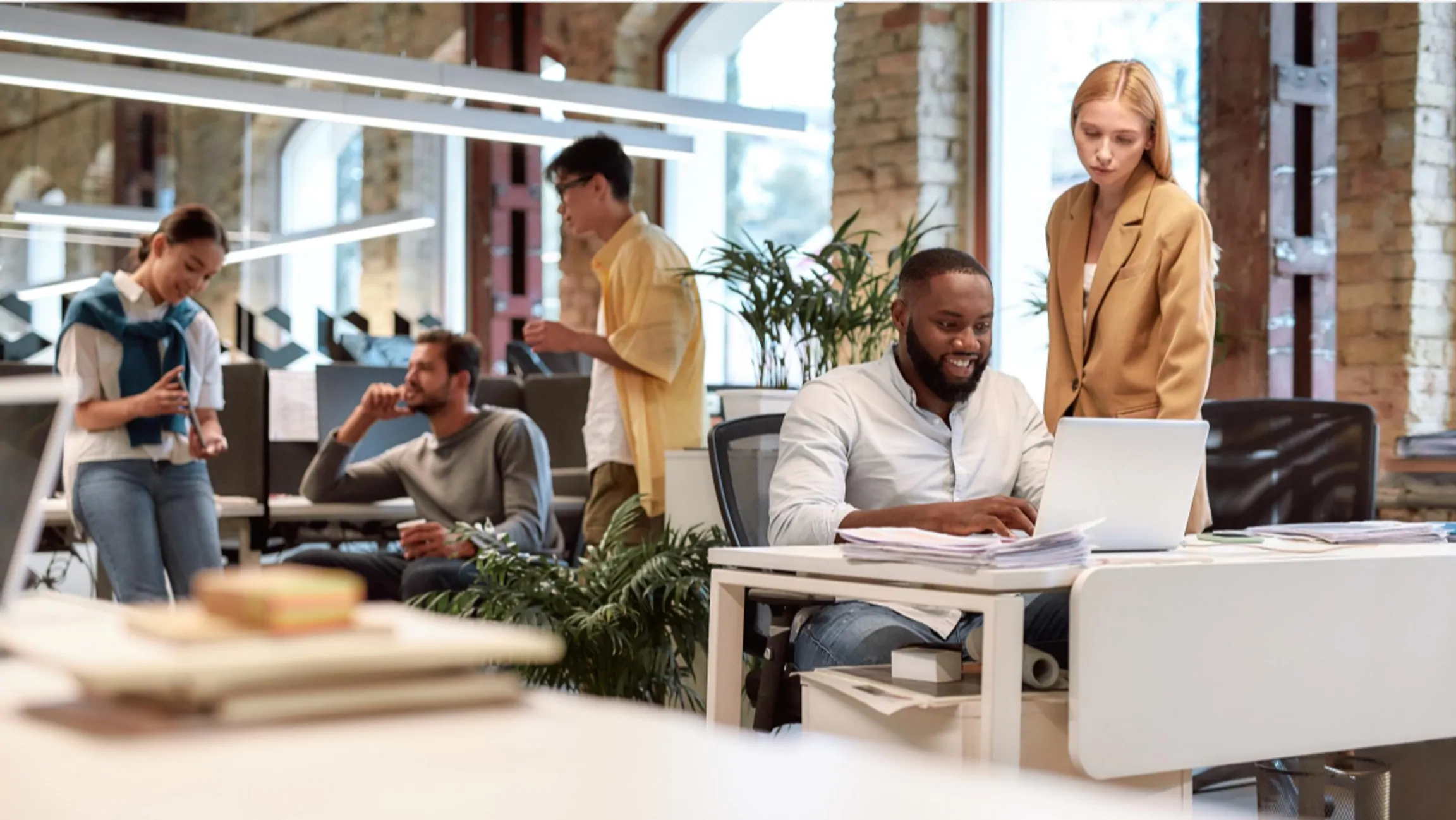 Adults from different backgrounds working together in a bright shared office.